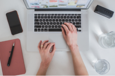 Homem sorridente criando um curso online em seu laptop com ícones de sucesso ao redor.