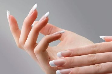 Mulher em salão de beleza fazendo alongamento de unhas com kit profissional.