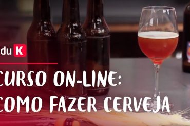 Curso de Cerveja Artesanal Produção Eduk 2019 - Homem sorrindo ao segurar um copo de cerveja artesanal em uma cozinha bem iluminada.