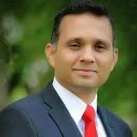 Homem sorrindo exibindo um celular com notificações de vendas e gráfico de lucro ascendente, representando o curso Ticket Baixo Lucrativo de Romulo Marques.