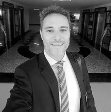 Homem de negócios confiante apresentando gráficos de vendas ascendentes, com o logo do curso Conquer Plus em destaque.