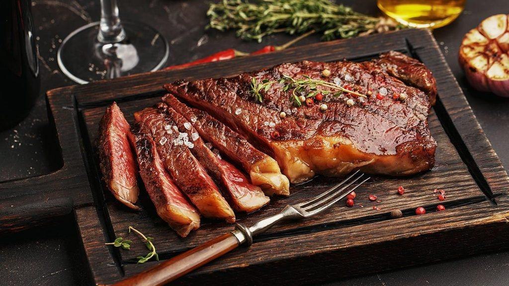 Capa do curso Churrasco On-line de Netão com cortes de carne e utensílios de churrasco.