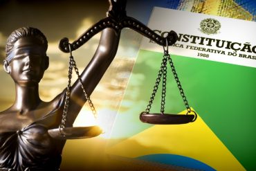 Professor ensinando Direito Constitucional para concursos com material Estratégia Concursos
