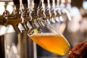 Curso Introdução ao Mundo das Cervejas por Felipe Vasconcellos com garrafas e copos de cerveja artesanal.