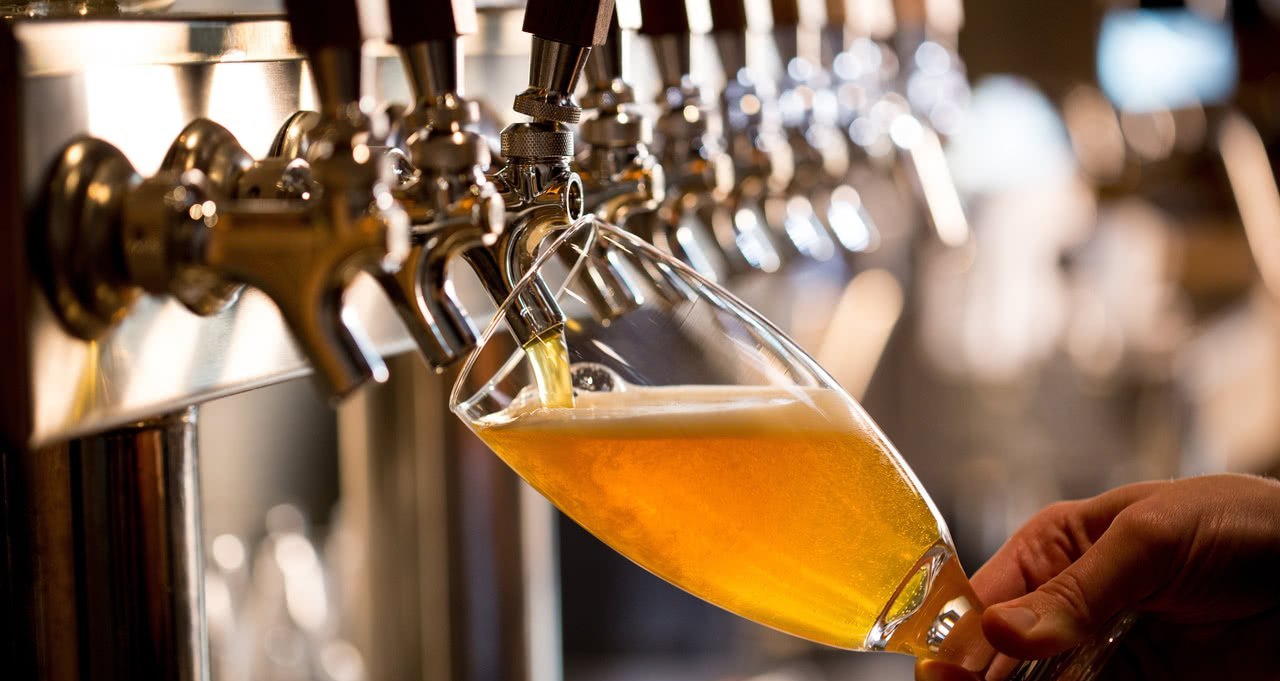 Curso Introdução ao Mundo das Cervejas por Felipe Vasconcellos com garrafas e copos de cerveja artesanal.