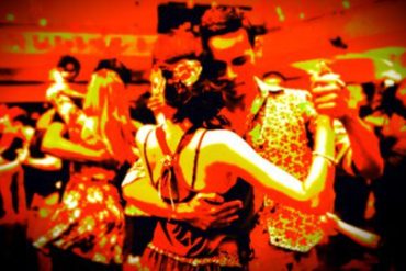 Homem e mulher dançando forró com alegria em um salão, com foco nos movimentos e na conexão do casal.