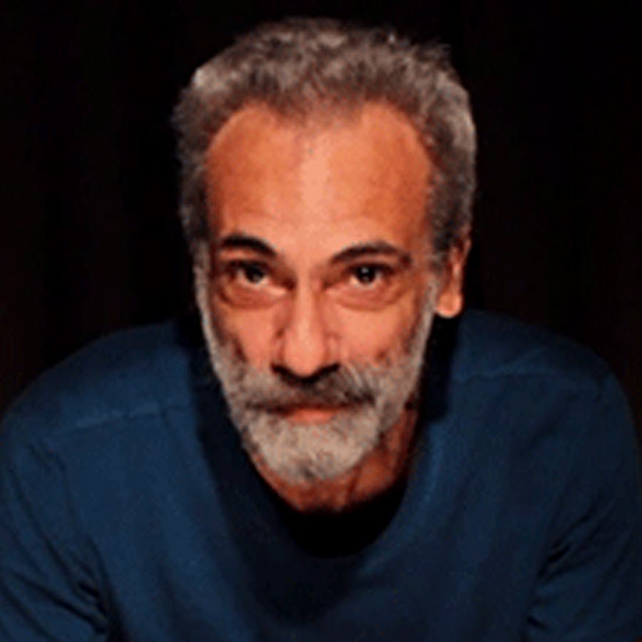 Homem sorrindo, expressando confiança com a voz, em um ambiente profissional iluminado, curso Roberto Mallet